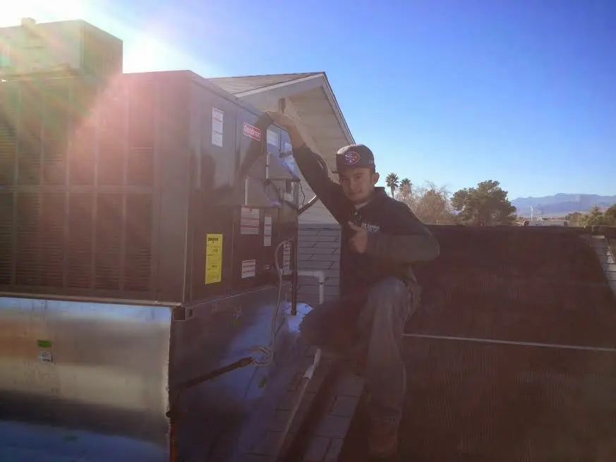 HVAC technician performing AC Tune-Up on a rooftop unit in Durham